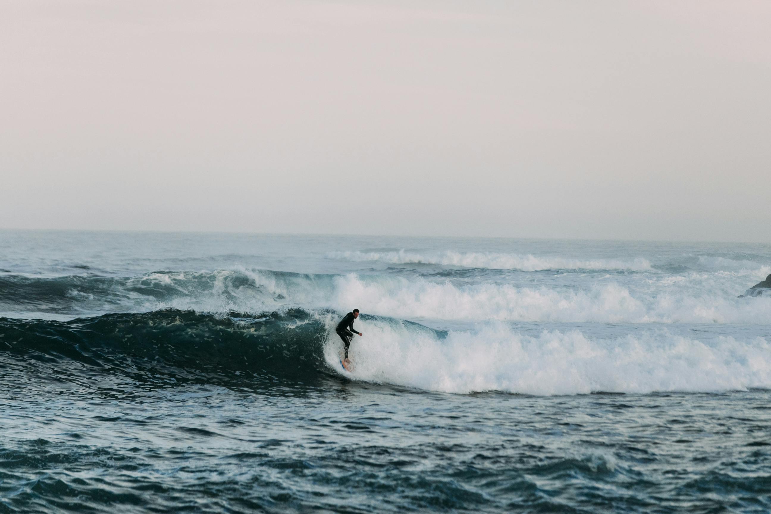 Surfer riding a wave in Essaouira with ocean spray and dynamic action